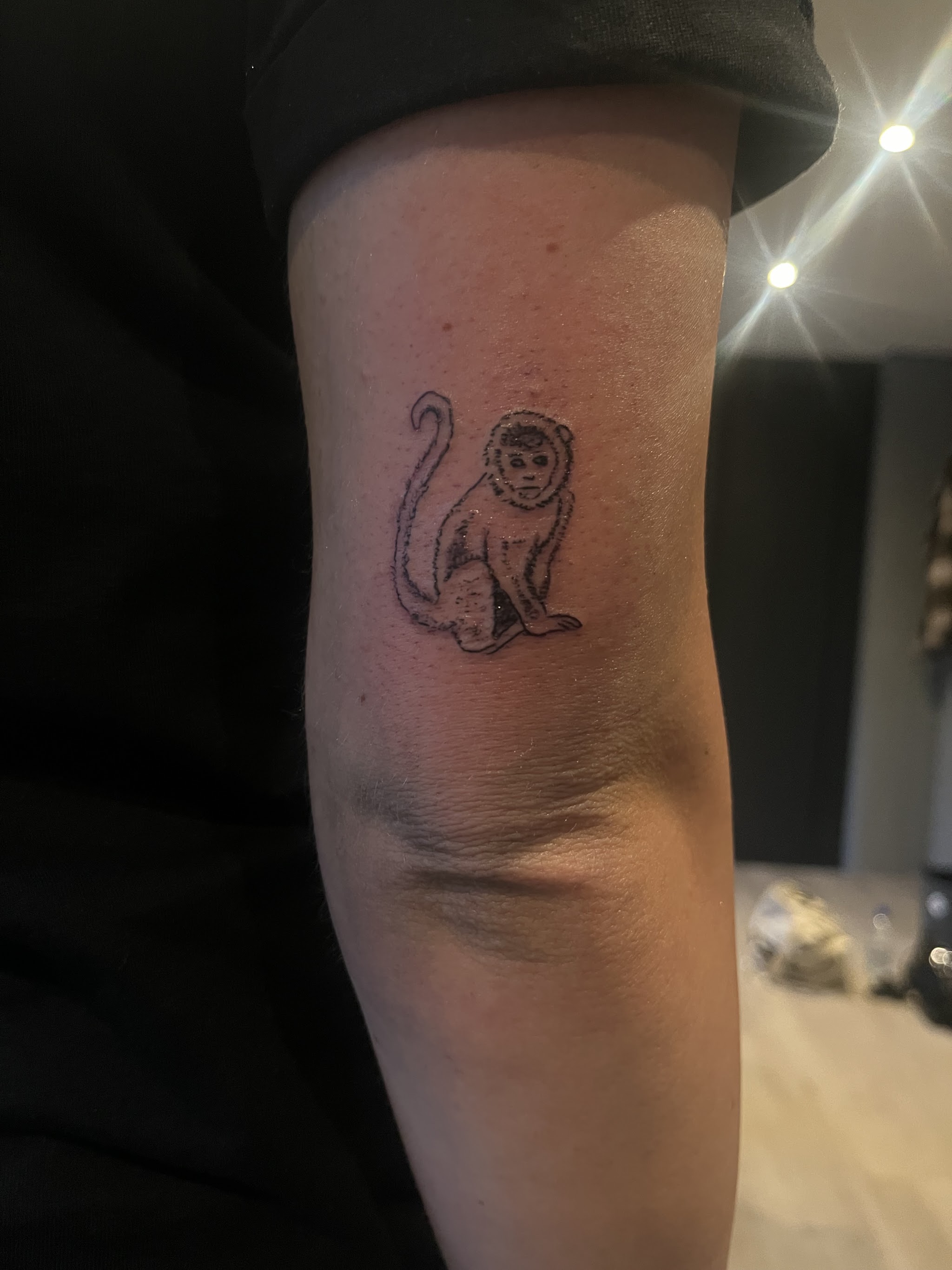 Klein aapje getatoeëerd op een bovenarm