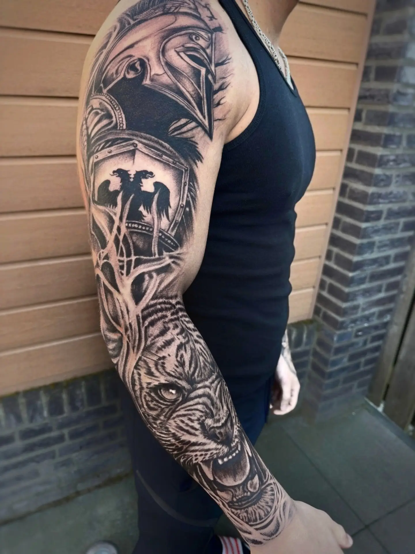 Volledige sleeve in zwart en grijs met een helm, een boom en een tijger